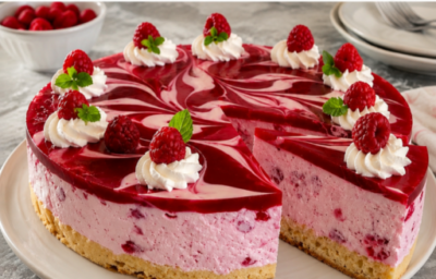 Himbeer-Rahmtorte mit cremiger Sahnefüllung, Himbeerschicht und frischen Himbeeren dekoriert